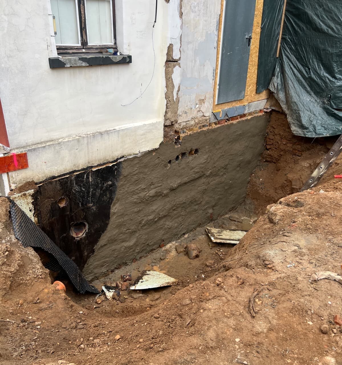 Freigelegte Kelleraussenwand mit neuer Au&szlig;enabdichtung
